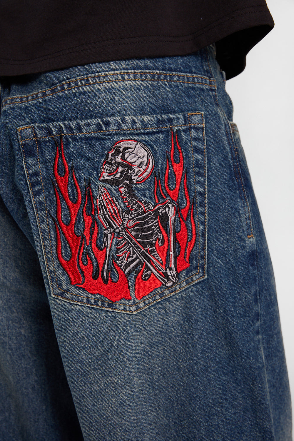 Jean coupe skateur à squelette et flammes brodés Jean coupe skateur à squelette et flammes brodés
